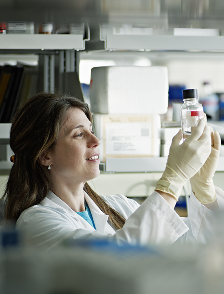 Female scientist examining bottle in research lab